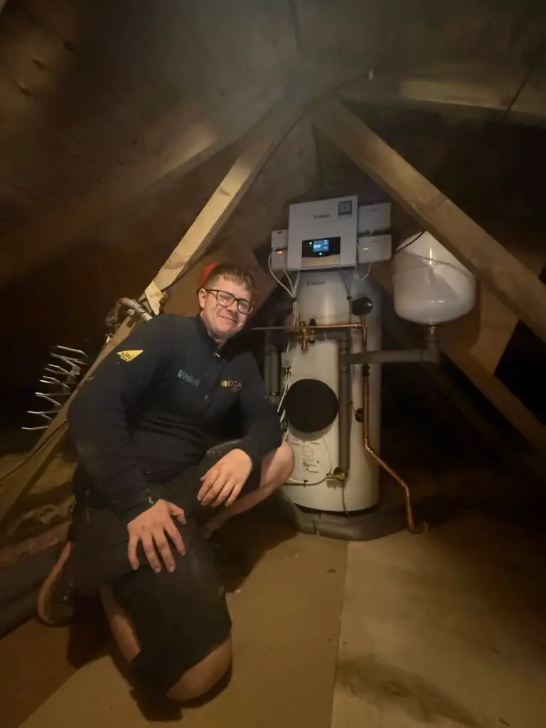 RCA Plumbing & Heating engineer beside the new Vaillant cylinder in the loft